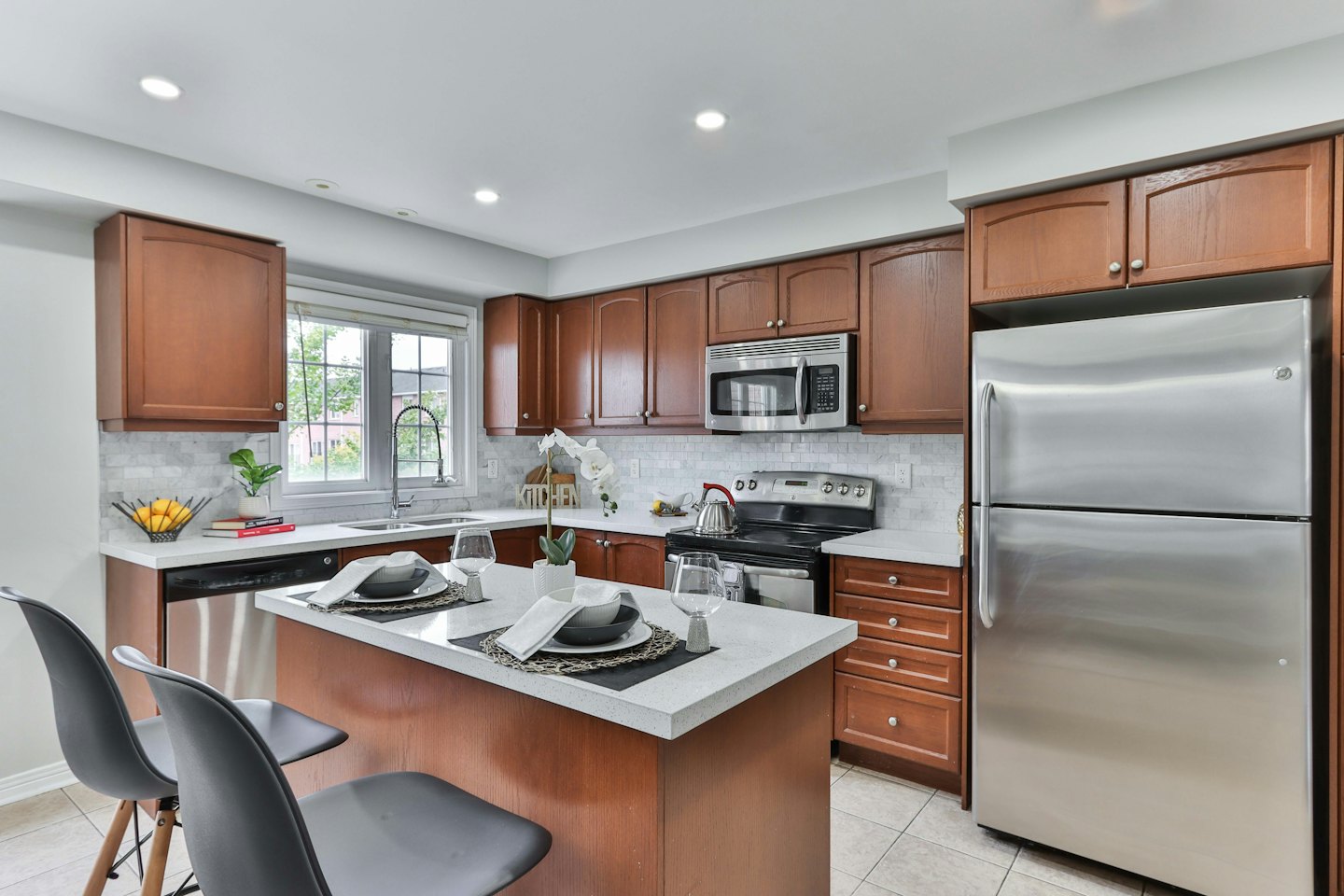 Modern kitchen with cherry cabinets and island seating.