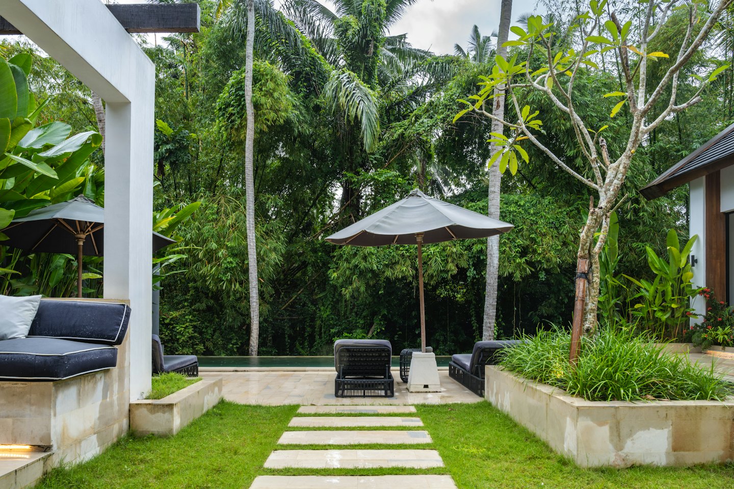Modern resort villa with a pool and tropical garden.