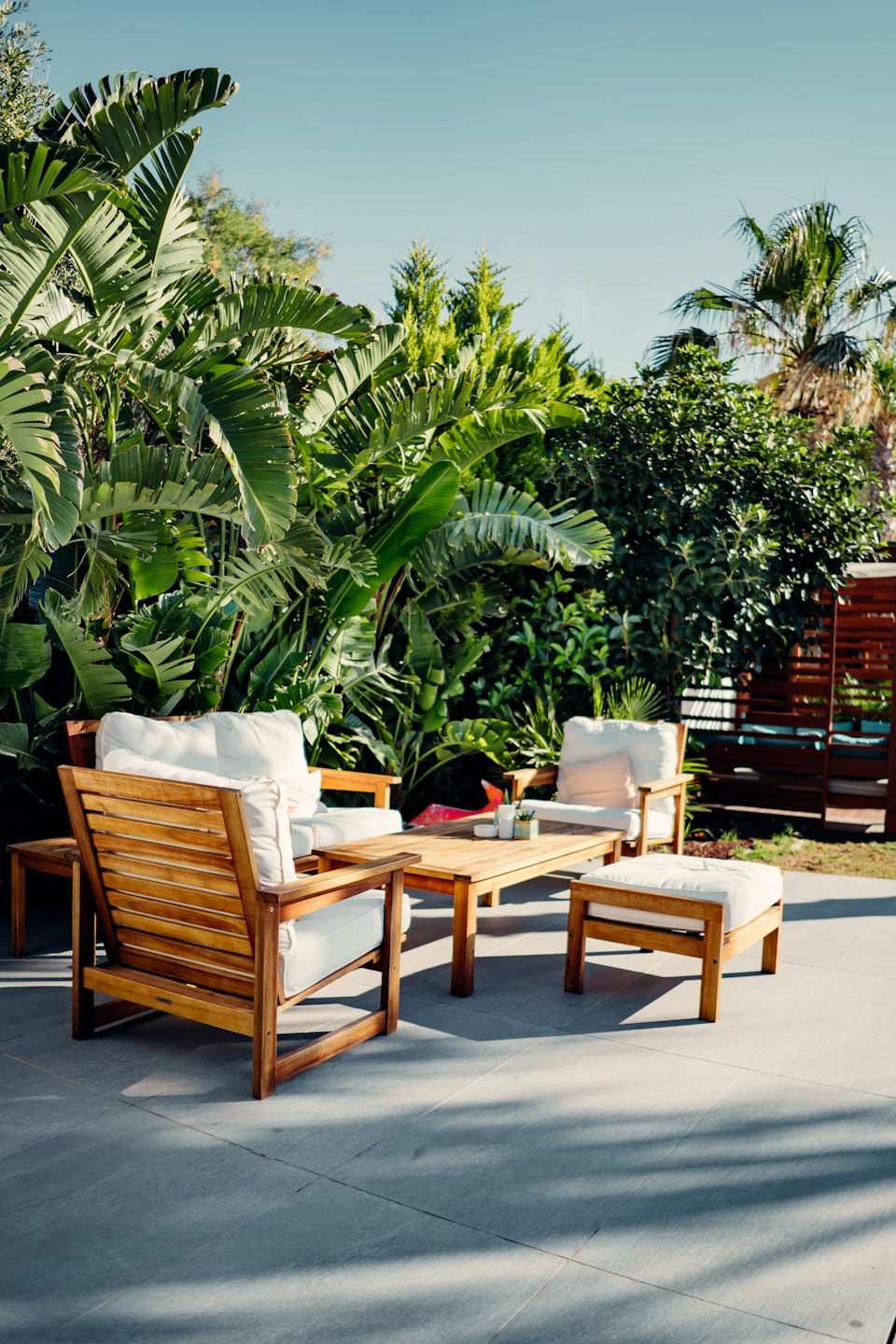 Modern patio furniture in a tropical garden setting.