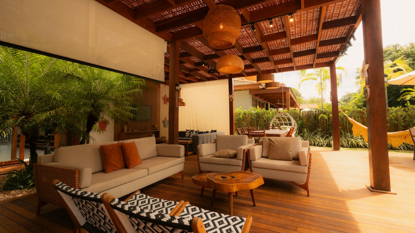 Outdoor living area with sofa and armchairs on a patio.